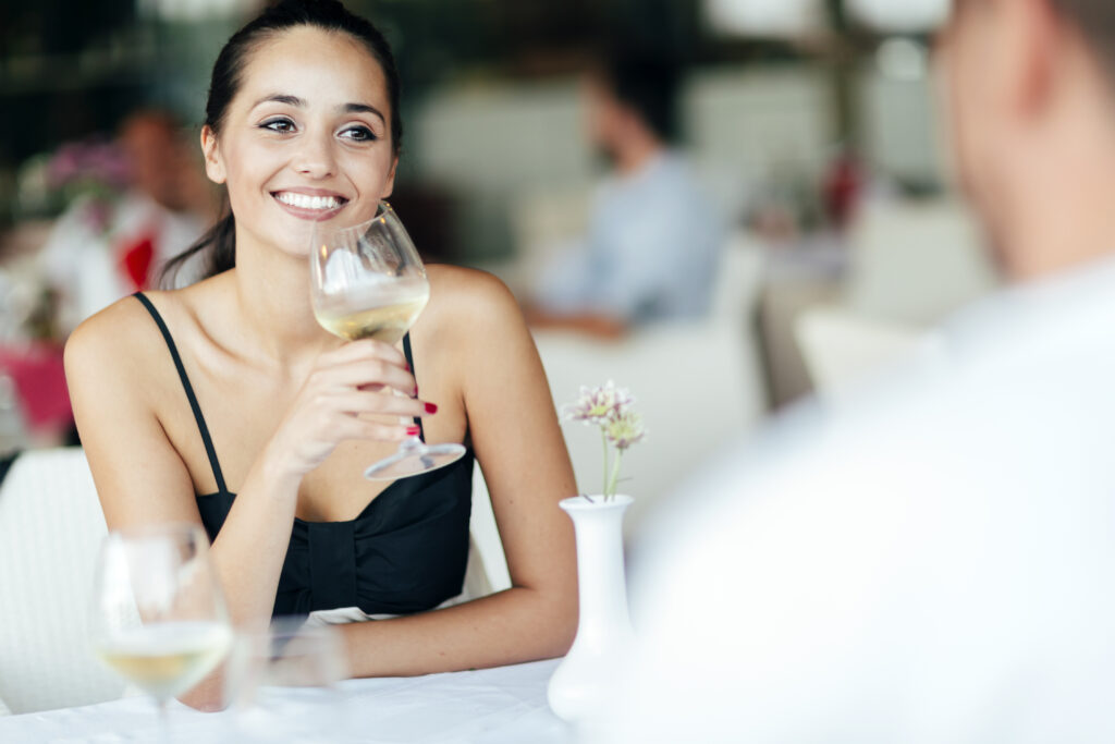 Couple celebrating in restaurant and having a glass of white wine